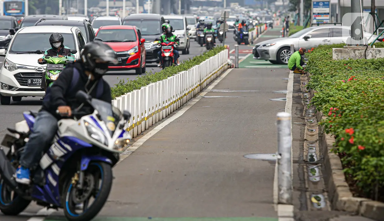 Kendaraan melintas di samping jalur khusus sepeda yang diberikan pembatas jalur permanen di Jalan Sudirman, Jakarta, Kamis (17/6/2021). Kapolri Jenderal Listyo Sigit Prabowo akan membongkar jalur sepeda di Sudirman-Thamrin dan mempelajari jalur sepeda di negara lain. (Liputan6.com/Faizal Fanani)