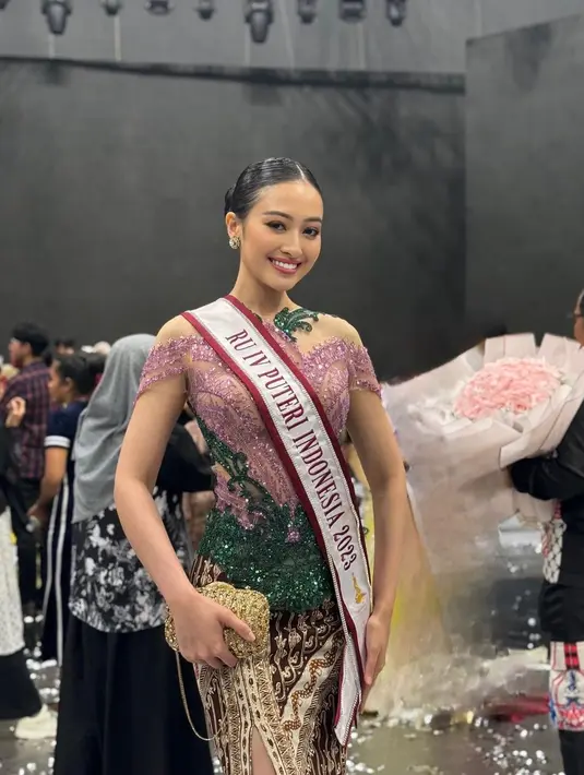 Selain memiliki visual cantik memesona, Puteri Modiyanti juga dikenal cerdas. Tak main-main, ia pernah menjadi Runner Up Puteri Indonesia 2023. Di foto ini, Puteri Modiyanti mengenakan kebaya modern penuh payet berwarna ungu dan hijau, dipadukan dengan kain batik sebagai rok dengan high slit. [Foto: Instagram/putmod]