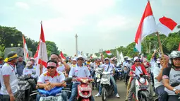 Massa dari Pergerakan Pelaut Indonesia (PPI) membawa atribut bendera ketika berunjuk rasa di Jalan Merdeka Barat, Jakarta, Kamis (12/5). Massa menuntut pemerintah memperhatikan kesejahteraan dan peningkatan upah mereka. (Liputan6.com/Yoppy Renato)