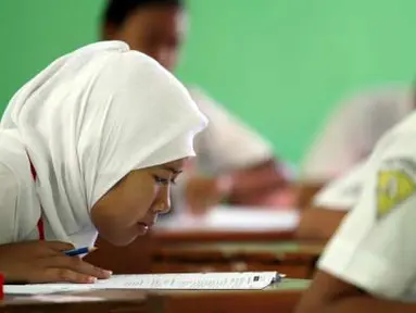 Seorang pelajar SMP serius membaca soal ujian saat mengikuti ujian nasional (UN) di SMP 1 Semen, Kediri, Jawa Timur, Senin (23/4). Sebanyak 3.740.043 siswa SMP/MTs/SMPLB/SMPT seluruh Indonesia mengikuti UN untuk menentukan kelanjutan pendidikan ke jenjang berikutnya. (Antara)