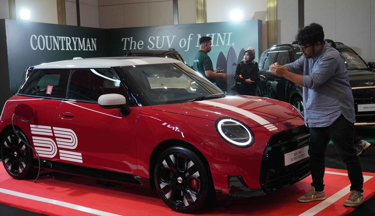 MINI 1965 Victory Edition terinspirasi kemenangan legendaris MINI Cooper S di ajang Monte Carlo Rally 1965. Tampak dalam foto, seorang pria memotret kendaraan listrik MINI 1965 Victory Edition selama acara peluncurannya di Jakarta, Jumat 17 April 2026. (AP Photo/Tatan Syuflana)