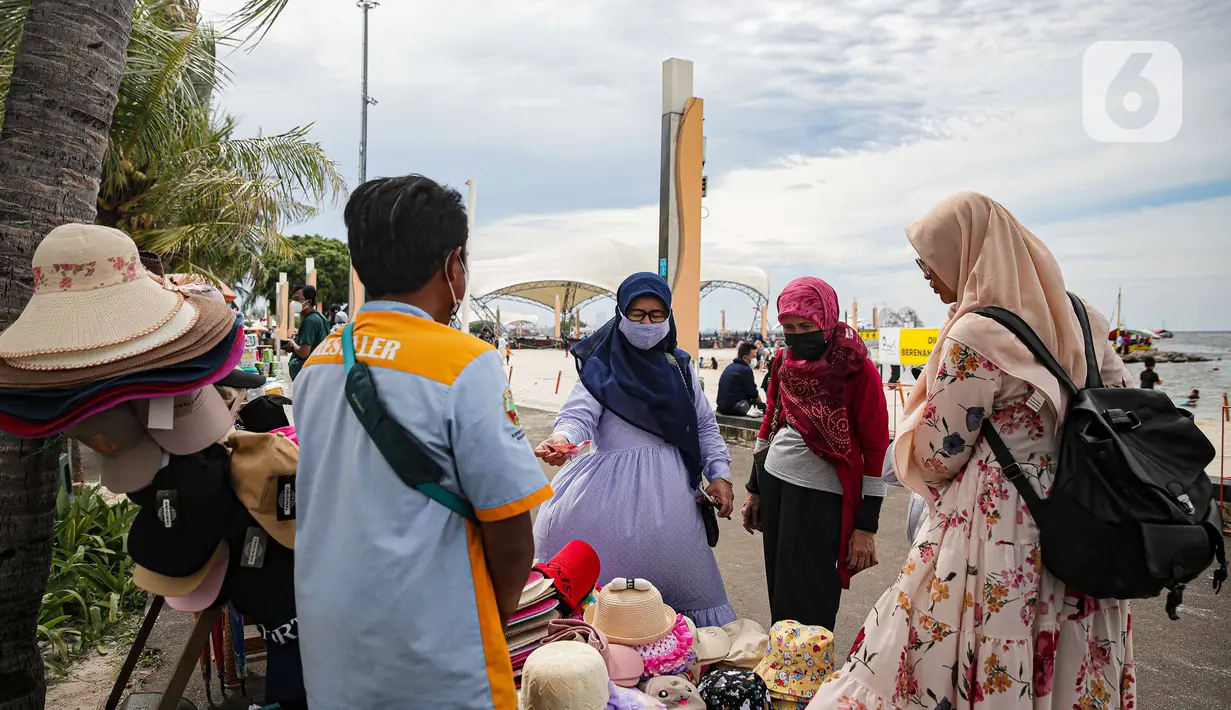 Wisatawan memilih topi di Pantai Ancol, Jakarta, Sabtu (25/12/2021). Libur Natal dimanfaatkan masyarakat berwisata ke Pantai Ancol, Kawasan Pantai Ancol merupakan salah satu objek wisata yang kerap menjadi tujuan wisatawan saat mengisi waktu liburan. (Liputan6.com/Faizal Fanani)