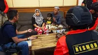 Petugas gabungan dari Polda Jatim dan Polres Pasuruan Kota menangkap pasangan suami istri (pasutri) yang bekerja sebagai tenaga kerja Indonesia (TKI) karena dugaan kasus penculikan anak. (Liputan6.com/ Dian Kurniawan)