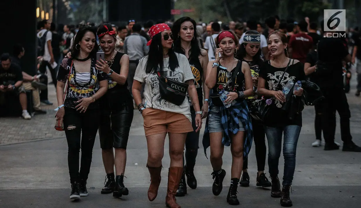 Sejumlah wanita berjalan untuk menyaksikan Konser Guns N’ Roses di Stadion Gelora Bung Karno, Jakarta, Kamis (8/11). Di konser ini Guns N' Roses juga akan meng-cover sejumlah lagu dari para penyanyi populer. (Liputan6.com/Faizal Fanani)