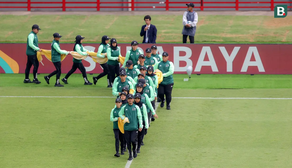 Sejumlah petugas membawa bendera untuk dibentangkan di tengah lapangan sebelum laga Piala Dunia U-17 2023 antara Timnas Mali U-17 melawan Timnas Kanada U-17 di Stadion Gelora Bung Tomo (GBT), Surabaya, Kamis (16/11/2023). (Bola.com/Bagaskara Lazuardi)