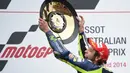 Valentino Rossi mengangkat trofi juara saat merayakan kemenangannya dalam MotoGP Australia di Phillip Island pada Oktober 2014.  (AFP /Peter Parks)