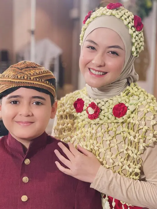 Revalina juga mengenakan ronce melati di atas kepalanya. Dengan makeup flawless mengaplikasikan lipstik pink glossy. [@vatemat]