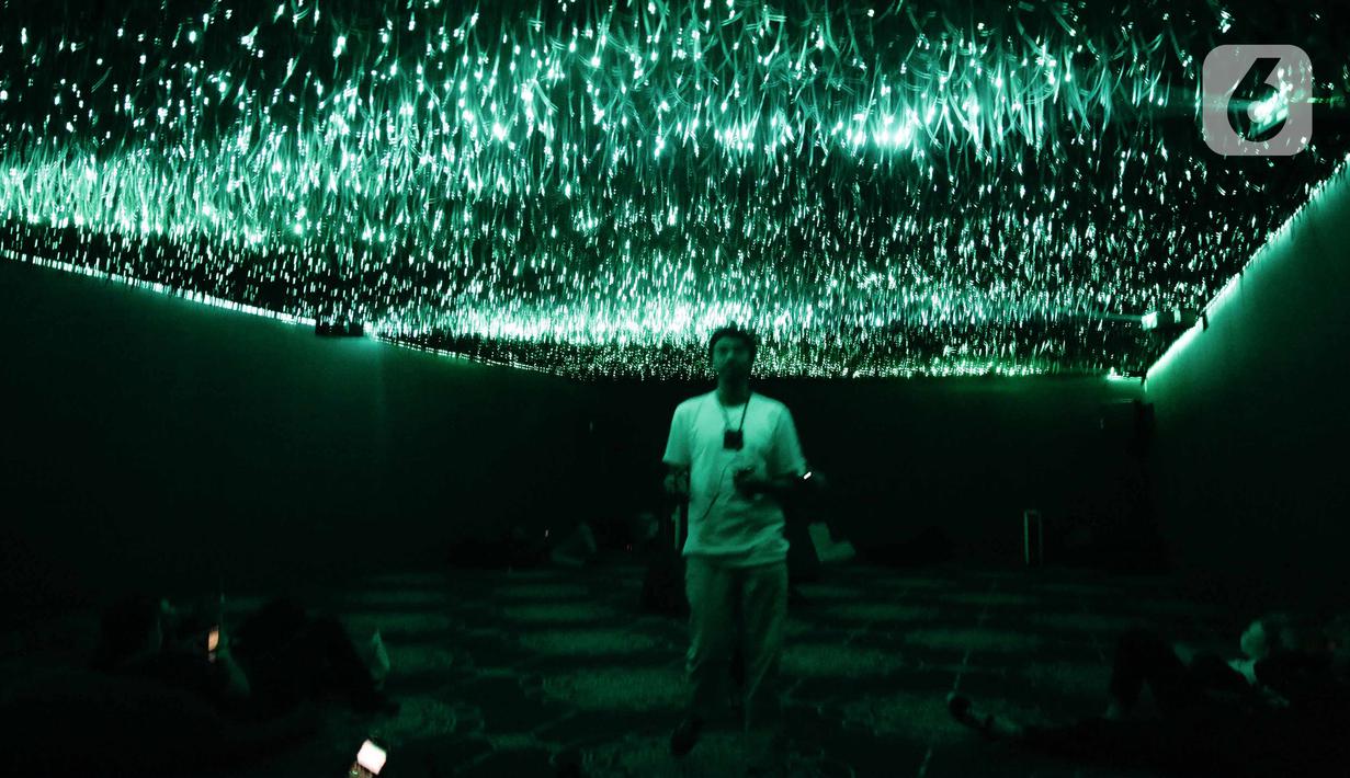 Pengunjung berpose saat mengunjungi pameran seni berbasis teknologi berwujud sorotan cahaya futuristik 'Wave of Tomorrow' di Jakarta, Sabtu (21/12/2019). Acara ini diselenggarakan dari 20-29 Desember 2019. (Liputan6.com/Faizal Fanani)