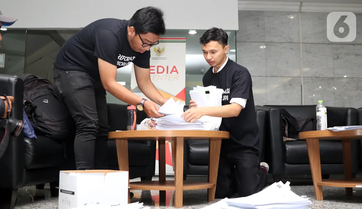 Perwakilan Koalisi Masyarakat Sipil Antikorupsi merapikan berkas-berkas jelang mendaftarkan pengajuan judicial review UU Nomor 19 Tahun 2019 tentang KPK di Gedung MK, Jakarta, Rabu (20/11/2019). (Liputan6.com/Helmi Fithriansyah)