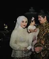 Pasangan seleb Atta Halilintar dan Aurel Hermansyah terlihat menghadiri acara tasyakuran pada sesi malam hari. Keduanya tampil serasi mengenakan kemeja batik dan kebaya modern brokat warna putih. @aurelie.hermansyah