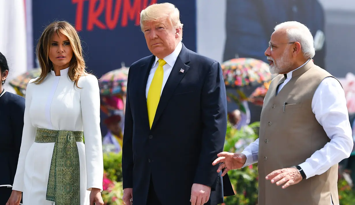 PM India, Narendra Modi berbincang dengan Presiden AS Donald Trump dan Melania Trump saat menyambut kedatangan mereka di Bandara Internasional Sardar Vallabhbhai Patel di Ahmedabad, Senin (24/2/2020). Ini merupakan kunjungan balasan Trump setelah Modi berkunjung ke AS pada 2019. (MANDEL NGAN/AFP)