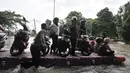 Pengendara sepeda motor menggunakan jasa rakit saat banjir melanda Cempaka Putih, Jakarta, Minggu (23/2/2020). Pengendara memanfaatkan jasa angkutan rakit yang ditawarkan warga agar dapat melewati banjir. (merdeka.com/Iqbal S. Nugroho)