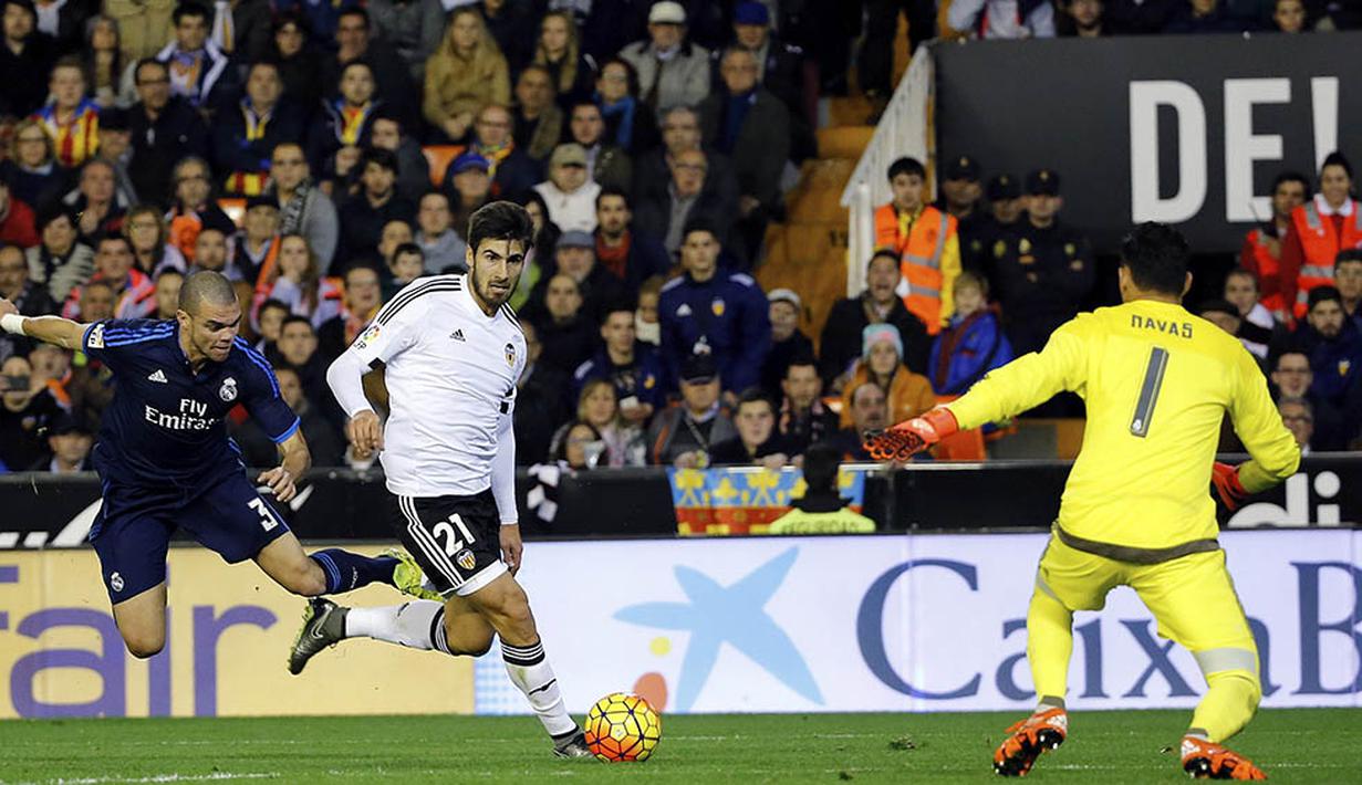 Gelandang Valencia, Andre Gomes, berhasil melewati hadangan bek Real Madrid, Pepe, pada laga La Liga Spanyol. Valencia kini berada pada posisi 10 klasemen sementara. (EPA/Juan Carlos Cardenas)