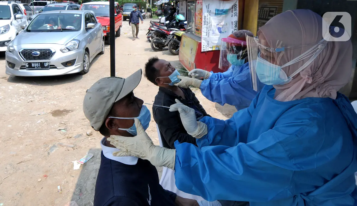 Paramedis melakukan swab antigen kepada para pemudik di perbatasan Depok-Bogor, Jalan Raya Parung-Ciputat, Depok, Jawa Barat, Minggu (16/5/2021). Mulai hari ini, diberlakukan swab antigen kepada para pemudik yang akan kembali ke wilayah Depok. (merdeka.com/Arie Basuki)