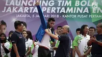 Direktur Pemasaran Pertamina Muchamad Iskandar (kedua kanan) mengenakan jaket kepada kapten tim putra Agung Seganti (tengah) saat Launching Tim Bola Voli Jakarta Pertamina Energi di Kantor Pusat Pertamina, Jakarta, Jumat (5/1).(Liputan6.com/Arya Manggala)