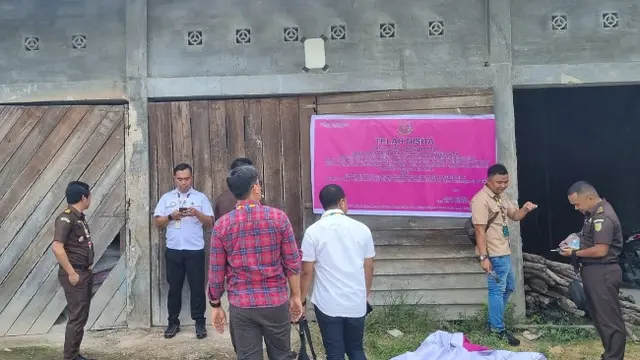 Jaksa dari Kejari Siak memasang tanda penyitaan terhadap aset tersangka korupsi pupuk bersubsidi.
