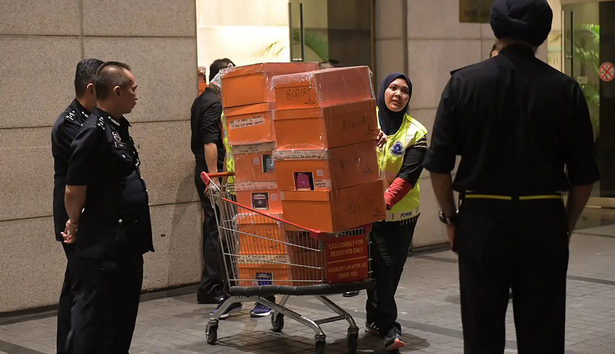 Polisi Malaysia membawa tas mewah yang disita dalam penggeledahan di tiga apartemen mantan Perdana Menteri, Najib Razak di Kuala Lumpur, Jumat (18/5). Polisi menyita 284 tas tangan mewah termasuk Hermes dan Birkin. (ARIFFIN JAMAR/THE STRAITS TIMES/AFP)