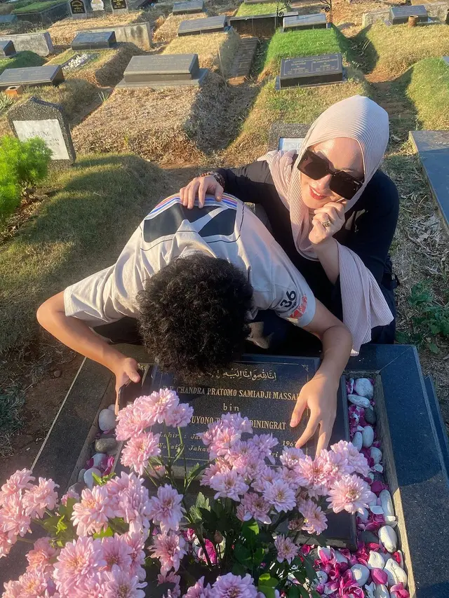 Angelina Sondakh dan anaknya di makam Adjie Massaid (Instagram/angelinasondakh09)