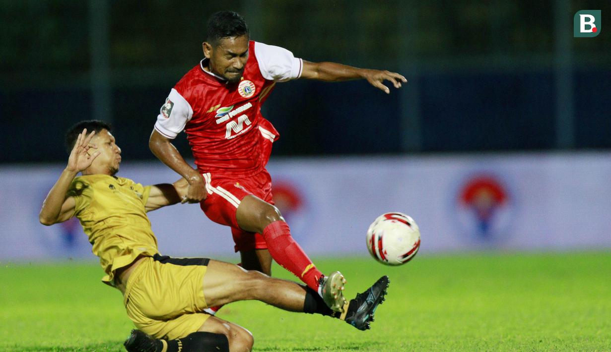 Gelandang Bhayangkara Solo FC, TM Ichsan (kiri) berebut bola dengan gelandang Persija Jakarta, Ramdani Lestaluhu dalam laga matchday ke-3 Grup B Piala Menpora 2021 di Stadion Kanjuruhan, Malang, Rabu (31/3/2021). (Bola.com/M Iqbal Ichsan)