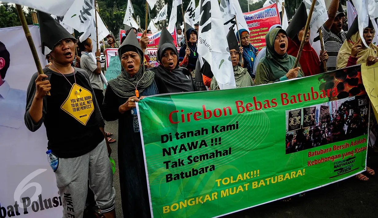 Massa membentangkan spanduk ketika menggelar aksi protes di Istana Negara, Jakarta, Senin (10/10). Mereka menolak pembukaan kembali bongkar muat batubara di Pelabuhan Cirebon yang akan mengakibatkan banyak warga terkena ISPA. (Liputan6.com/Faizal Fanani)
