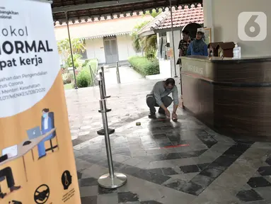 Petugas memasang tanda jaga jarak untuk antrean pengunjung di pintu masuk Museum Kebangkitan Nasional, Jakarta, Senin (8/6/2020). Pengelola menyiapkan standar protokol kesehatan jelang dibuka kembali untuk umum saat masa PSBB Transisi guna memutus penyebaran Covid-19. (merdeka.com/Iqbal S Nugroho)