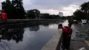 Sejumlah bocah melihat Anak Kali Ciliwung yang sedang meluap, Jakarta Pusat, Jumat (5/12/2014). (Liputan6.com/Johan Tallo)