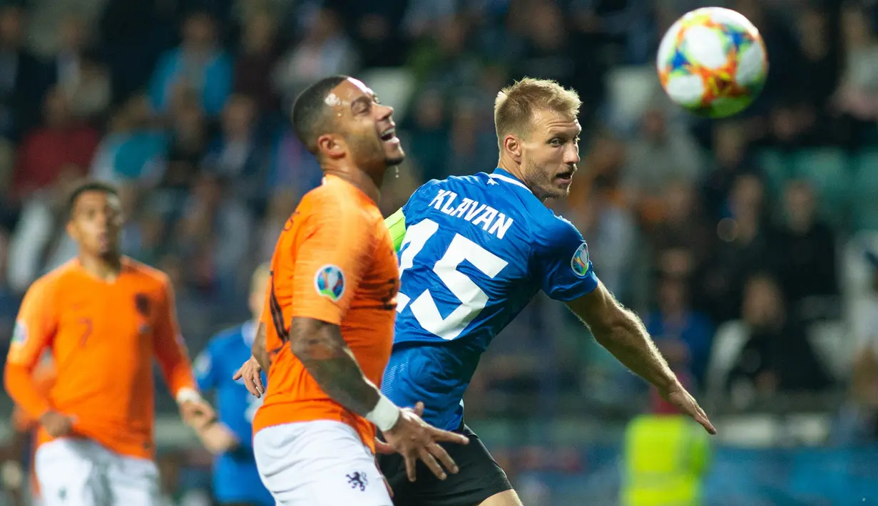 Bek Estonia, Ragnar Klavan, berebut bola dengan striker Belanda, Memphis Depay, pada laga Kualifikasi Piala Eropa 2020 di Talinn, Estonia, Senin (9/9). Estonia kalah 0-4 dari Belanda. (AFP/Raigo Pajula)