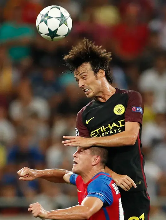Duel udara antara pemain Manchester City, David Silva dengan pemain Steaua Bucharest, Marko Momcilovic dalam play-off pertama Liga Champions di Arena Nationala, Selasa (16/8).  Man City membantai Steaua Bucharest 5-0. (REUTERS)