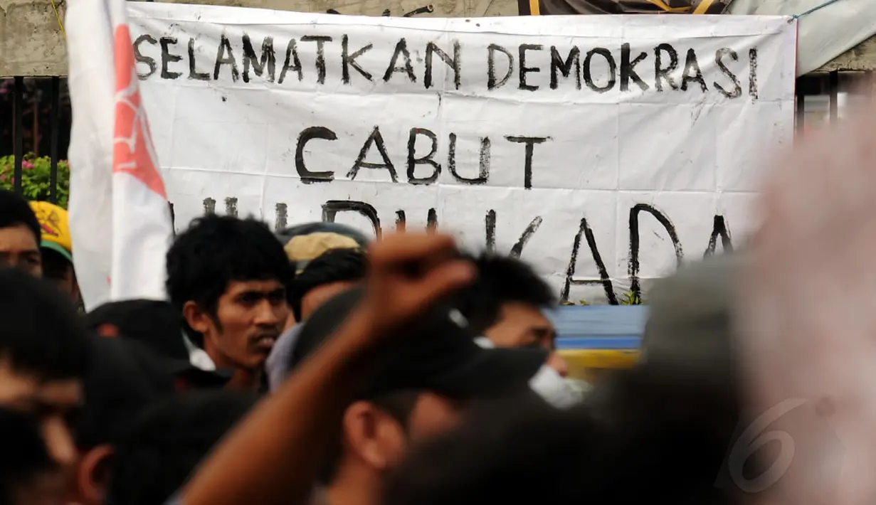 Beberapa spanduk dukungan pelaksanaan Pilkada Langsung dibentangkan di pagar jalan tol dalam kota persis di depan gedung DPR RI, Jakarta, (14/10/2014). (Liputan6.com/Helmi Fithriansyah)