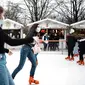 Pengunjung memakai masker untuk mencegah penyebaran COVID-19 saat bermain ice skating di pasar malam di Paris, Prancis, 29 Desember 2021. Lonjakan kasus baru COVID-19 di Prancis turut diakibatkan varian Omicron. (AP Photo/Thibault Camus)