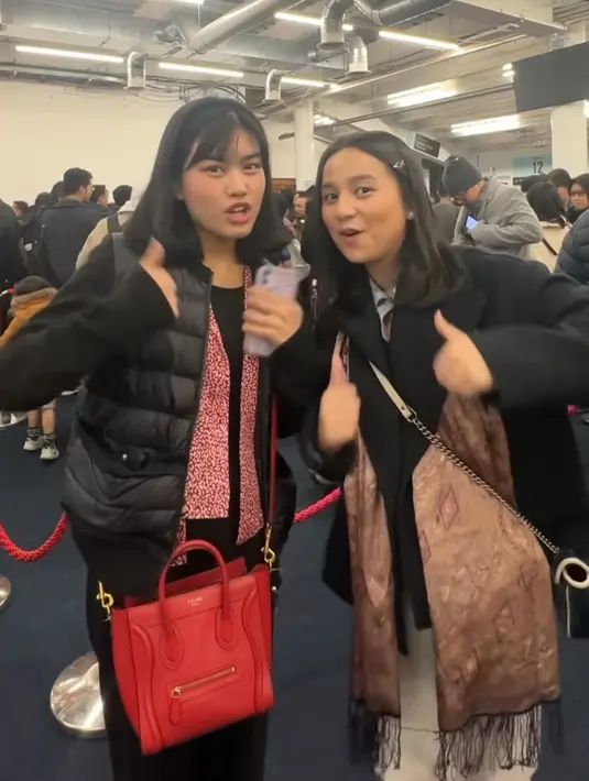 Atasan tersebut dipadukan celana panjang hitam, sambil membawa tas merah. [@namirazhra]