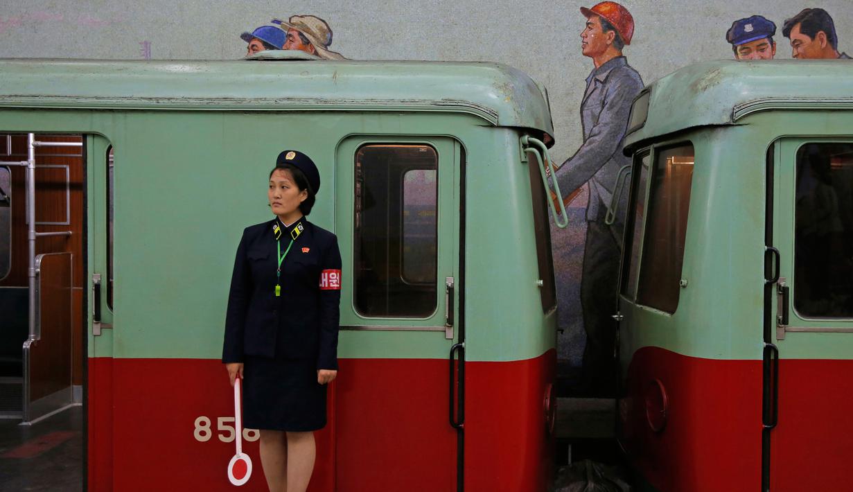 Seorang petugas berdiri dekat kereta yang tengah berhenti di stasiun kereta bawah tanah atau metro Pyongyang, Korea Utara, 13 September 2018. Kereta yang digunakan merupakan peninggalan masa Jerman Timur. (AP Photo/Kin Cheung)