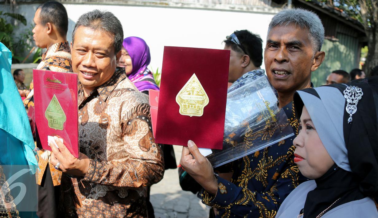 Seorang tamu memperlihatkan undangan resepsi pernikahan Gibran Rakabuming putra sulung Presiden Joko Widodo dan Selvi Ananda di Gedung Graha Saba Buana, Solo, Jawa Tengah, Kamis (11/6/2015). (Liputan6.com/Faizal Fanani)