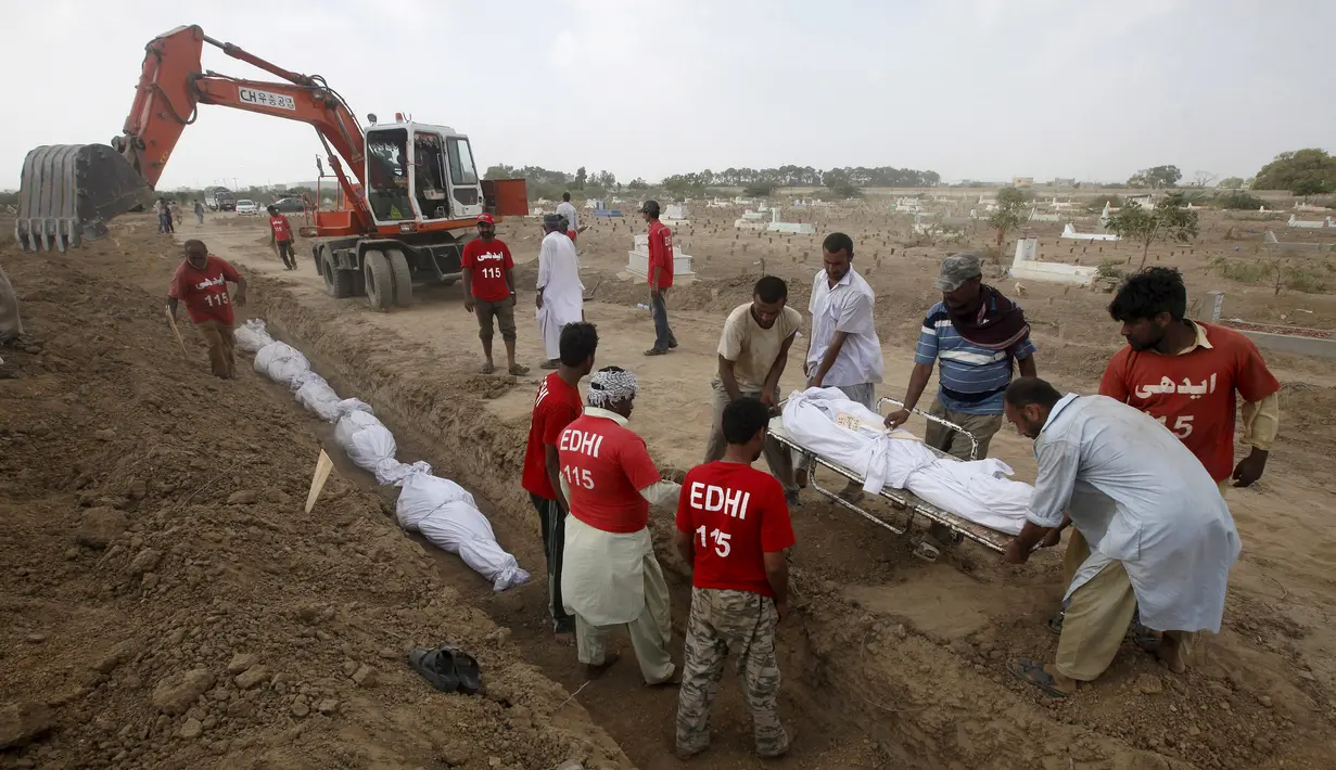 Relawan menguburkan jenazah korban tewas akibat gelombang panas saat pemakaman massal di Karachi, Pakistan, Jumat (26/6/2015). Lebih dari 1.150 orang tewas akibat gelombang panas. (REUTERS/Akhtar Soomro)
