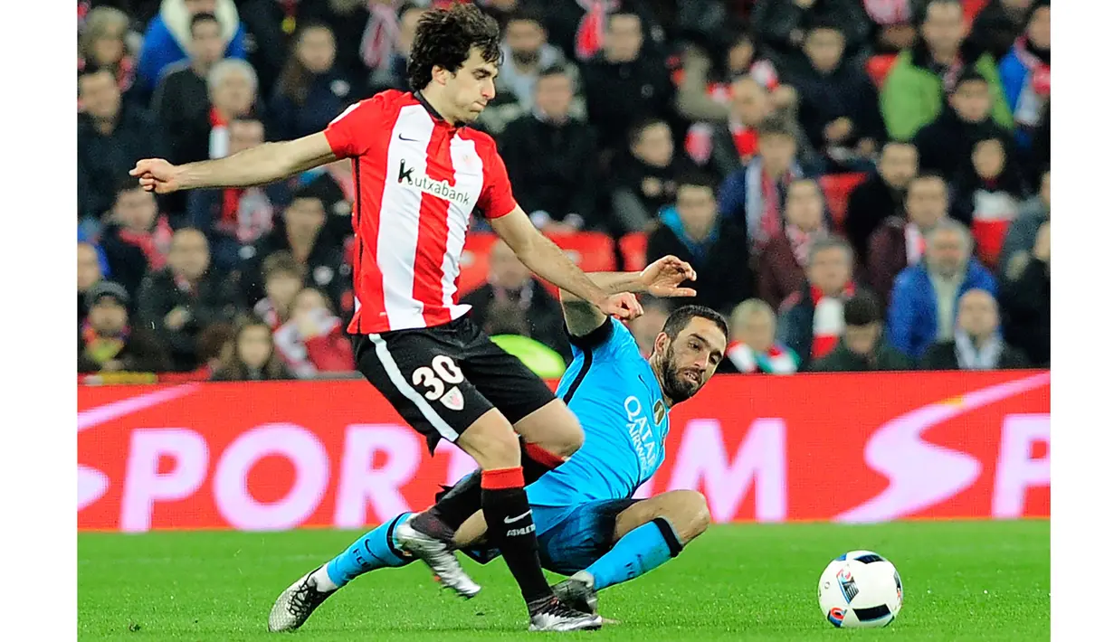 Pemain Athletic Bilbao, Inigo Lekue (kiri)  mencoba menghalau bola dari pemain Barcelona, Arda Turan (kanan)  pada Leg pertama perempat final Copa Del Rey di Stadion San Mames,Bilbao, Spanyol, Kamis (21/1/2016) dini hari WIB. (AFP/Ander Gillenea)