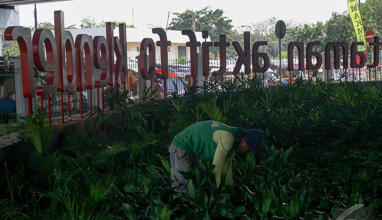 Seorang pekerja sedang menanam tanaman hias di Taman Aktif of Klender, Jakarta, Senin (22/9/2014) (Liputan6.com/Faizal Fanani)