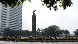 Para pebalap melewati patung Selamat Datang pada ajang Tour de Jakarta di Bundaran Hotel Indonesia, Jakarta, Sabtu (30/7/2016). (Bola.com/Nicklas Hanoatubun)