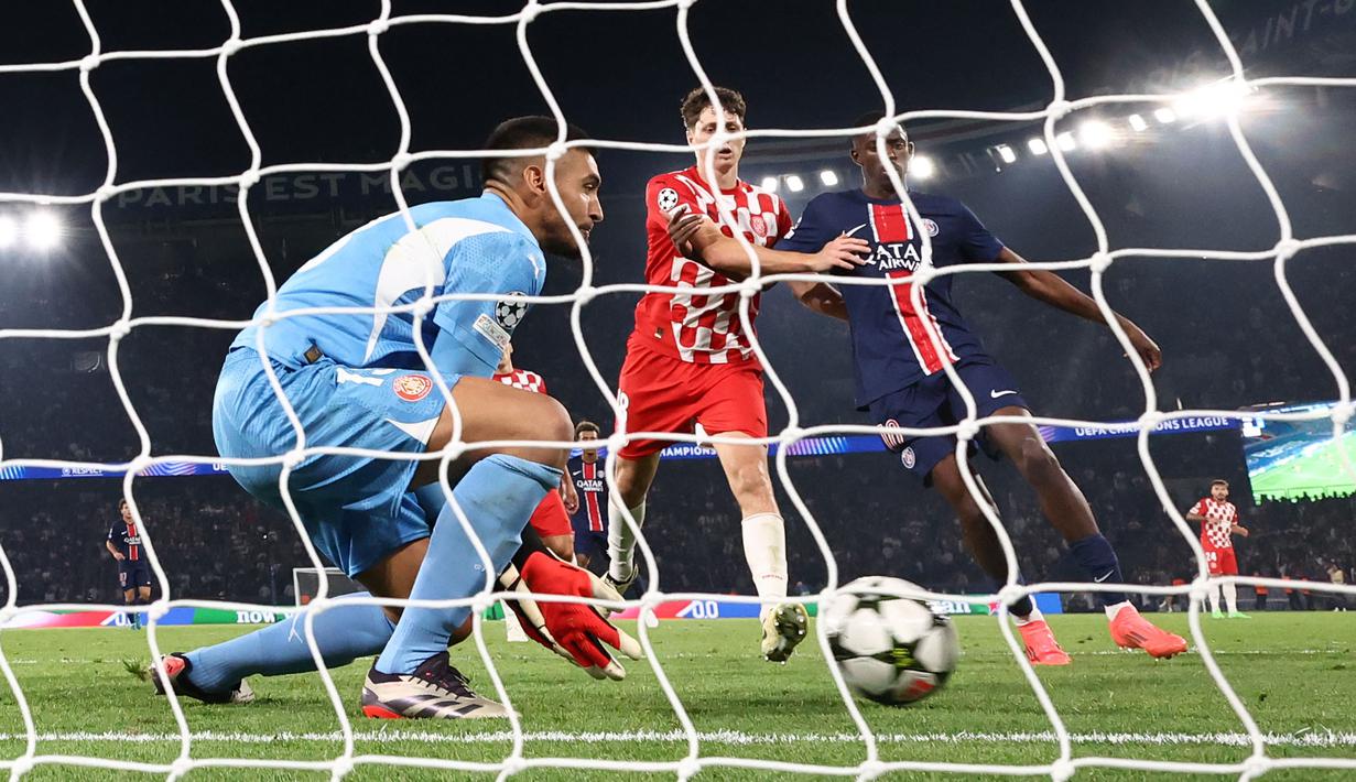 Kiper Girona, Paulo Gazzaniga (kiri) berusaha menangkap bola umpan silang dari PSG, Nuno Mendes pada laga Liga Champions 2024/2025 yang berlangsung di Parc des Princes, Paris, Prancis, Kamis (19/09/2024). (AFP/Franck Fife)