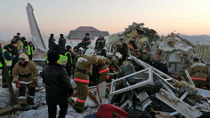 Polisi dan petugas penyelamat di antara puing-puing  pesawat maskapai Bek Air yang jatuh di dekat Bandara Almaty, Kazakhstan, Jumat (27/12/2019). Sedikitnya sudah 14 orang dilaporkan tewas dan 35 lainnya luka. ( Emergency Situations Ministry of the Republic of Kazakhstan photo via AP)