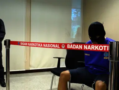 Tersangka AR yang menjadi kurir dihadirkan dalam rilis di kantor BNN, Jakarta, Selasa (27/10/2015). BNN mengamankan empat tersangka kasus narkoba dengan barang bukti 1000 butir pil ekstasi, dua diantaranya merupakan oknum TNI. (Liputan6.com/Yoppy Renato)