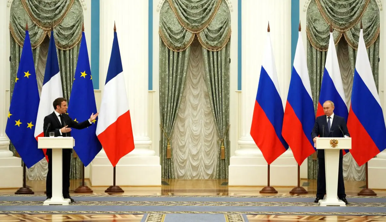 Presiden Rusia Vladimir Putin (kanan) mendengarkan saat konferensi pers bersama Presiden Prancis Emmanuel Macron di Moskow, Rusia, 7 Februari 2022. Emmanuel Macron menemui Vladimir Putin untuk meredakan kebuntuan atas Ukraina. (Thibault Camus/POOL/AFP)