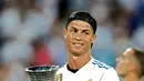 Penyerang Real Madrid, Cristiano Ronaldo memegang trofi Piala Super Spanyol 2017 usai pertandingan melawan Barcelona di stadion Santiago Bernabeu, Spanyol (16/8). Real Madrid menang 2-0 atas Barcelona dengan skor agregat 5-1. (AP Photo/Francisco Seco)