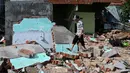 Badan Penanggulangan Bencana Vietnam menyebut sekitar 2.800 rumah mengalami kerusakan dan lebih dari 1,3 juta penduduk kehilangan akses listrik. Tampak dalam foto, seorang warga berjalan di atas puing-puing bangunan yang hancur akibat angin kencang di desa nelayan Nhon Hai dekat Quy Nhon, Provinsi Gia Lai, Vietnam Tengah, pada Jumat 7 November 2025. (NHAC NGUYEN/AFP)