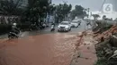 Kendaraan bergerak perlahan melintasi genangan lumpur di Jalan Raya Sawangan, Depok, Minggu (7/11/2021). Menurut warga setempat, banjir bercampur lumpur tersebut merupakan yang pertama kali yang diduga disebakan oleh proyek waduk perumahan yang belum rampung. (merdeka.com/Iqbal S Nugroho)