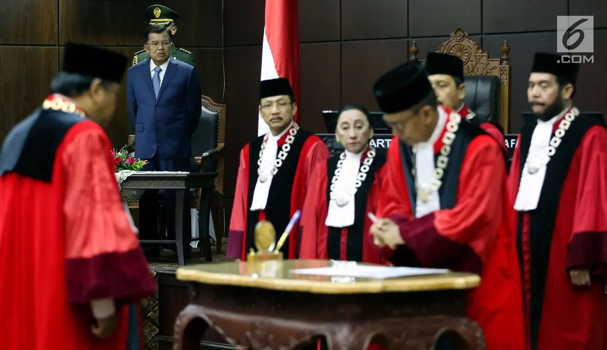 Wapres Jusuf Kalla menyaksikan penandatangan dokumen Ketua, Wakil dan Anggota Mahkamah Konstitusi usai pengambilan sumpah di Gedung MK, Jakarta, Jumat (14/7). Arief Hidayat kembali terpilih menjadi Ketua MK periode 2017-2020. (Liputan6.com/Johan Tallo)