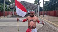 Militan Timnas Indonesia dari Kabupaten Gunung Kidul, Yogyakarta, bernama Katon, nekat melukis wajah Ketua PSSI, Erick Thohir, di perutnya saat akan menyaksikan Tim Garuda menghadapi Argentina di Stadion Utama Gelora Bung Karno (SUGBK) Senayan, Jakarta, Senin (19/6/2023).