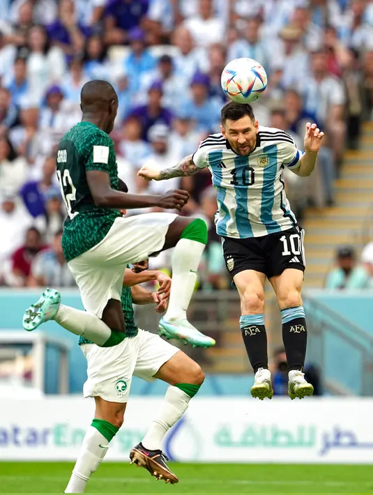 Pemain Argentina Lionel Messi (kanan) berebut bola udara dengan pemain pemain Arab Saudi Saud Abdulhamid pada pertandingan sepak bola Grup C Piala Dunia 2022 di Stadion Lusail, Lusail, Qatar, Selasa (22/11/2022). Arab Saudi mengalahkan Argentina dengan skor 2-1. (AP Photo/Ebrahim Noroozi)