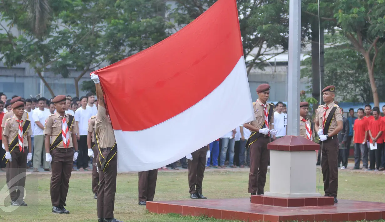 Petugas melakukan pengibaran bendera pada upacara peringatan 87 tahun Sumpah Pemuda di Lapas Narkotika Klas II A Cipinang, Jakarta, Rabu (28/10). Rencananya, upacara yang diikuti 2600 napi ini untuk memecahkan rekor MURI. (Liputan6.com/Gempur M Surya)