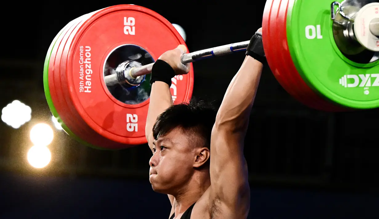 Lifter Indonesia, Rahmat Erwin Abdullah  berkompetisi dalam kompetisi angkat besi grup A 73kg putra Asian Games 2023 di Hangzhou, China, 3 Oktober 2023. (Ishara S.KODIKARA / AFP)