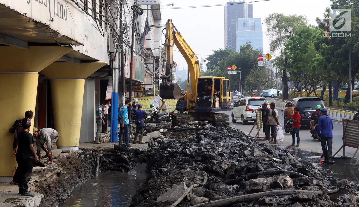 Alat berat membongkar saluran air (drainase) yang akan diperbaiki di jalan Hayam Wuruk, Jakarta Pusat, Selasa (20/11). Perbaikan dan pelebaran saluran air ini untuk mengantisipasi terjadinya banjir di kawasan tersebut saat hujan (Liputan6.com/Johan Tallo)